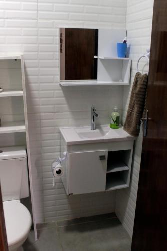 a bathroom with a sink and a toilet at Praia, piscina, churrasco e convívio com animais in Itanhaém