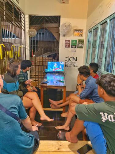 a group of people sitting in a room at Zion Backpackers Hostel in Guwahati