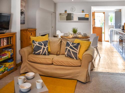 a living room with a couch and a table at Waverley Cottage in Mundesley