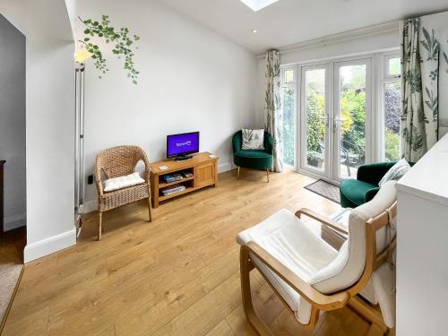 a living room with a couch and a tv at Rosemary House in Broadstairs