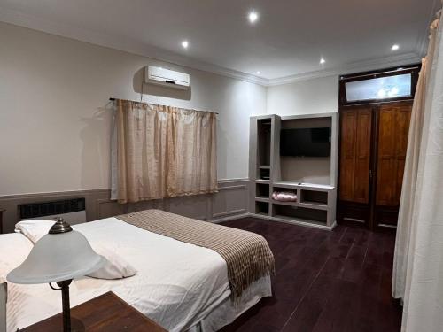 a bedroom with a bed and a flat screen tv at Hacienda Don Justo Hotel Boutique Spa in Colón