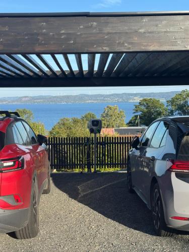 two cars parked next to each other next to a fence at Nyrenoverad 2-rummare med gratis laddning för elbil in Bankeryd