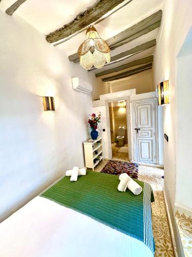a bedroom with a bed with a green blanket at Riad Green Palm in Marrakech