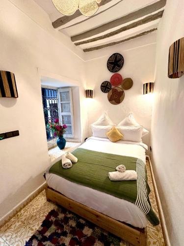 a bedroom with a bed with towels on it at Riad Green Palm in Marrakech