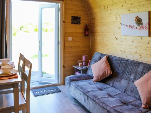 a living room with a couch and a table at Cuddfan - Uk49673 in Brynsiencyn