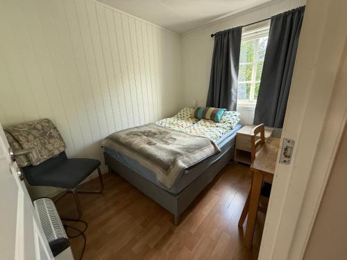 a small bedroom with a bed and a chair at Vistdal Panoramic View in Myklebostad