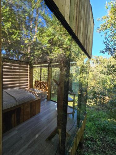 a bedroom in a tree house with a glass window at Aremko SPA in Puerto Varas