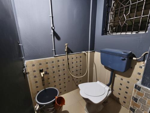a small bathroom with a toilet and a shower at Kanasu guest house in Gokarna