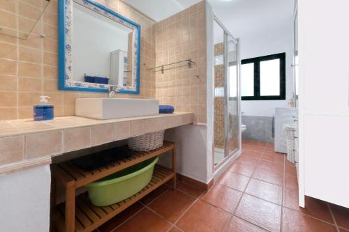 a bathroom with a sink and a mirror at Cocoteros Ocean View House in Guatiza
