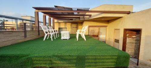 a patio with chairs and a table on a roof at Spacious 2BR Portion with Rooftop Gulshan e Iqbal Block 7 in Karachi