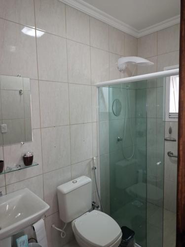 a bathroom with a toilet and a glass shower at Garcida in Governador Celso Ramos
