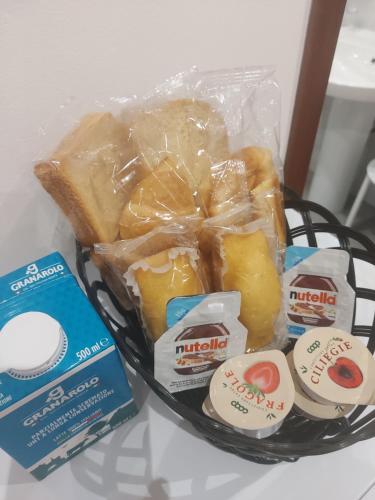a basket filled with different types of food on a table at Monreale Prestige Rooms B&B in Monreale