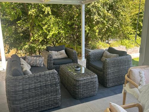 a group of wicker chairs and tables on a patio at SUITE 20m2 DANS VILLA PISCINE JACUZZI in Gattières