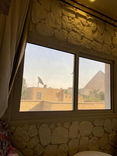 a window in a room with a view of the pyramids at Cheristo pyramids view inn in Cairo