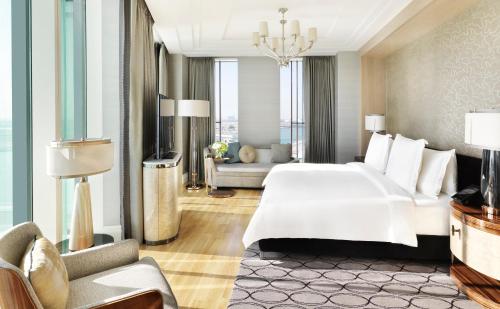 a bedroom with a large white bed and a couch at Four Seasons Hotel Abu Dhabi at Al Maryah Island in Abu Dhabi