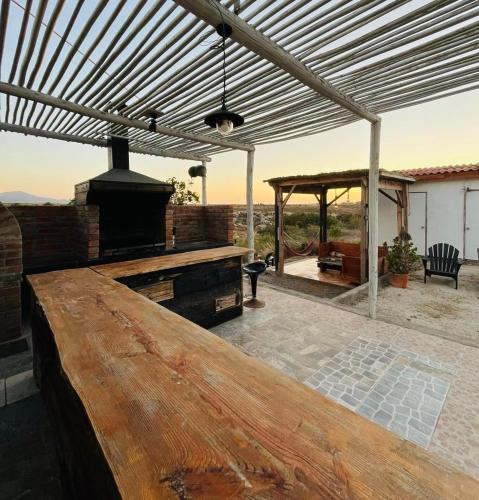 a patio with a wooden table and an outdoor grill at Eco Lodge Lorotuerto in Guanaqueros