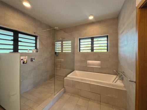 Un baño grande con bañera y ducha. en Pointe d'Azur Beachfront Homes - Pereybere, en Grand Baie