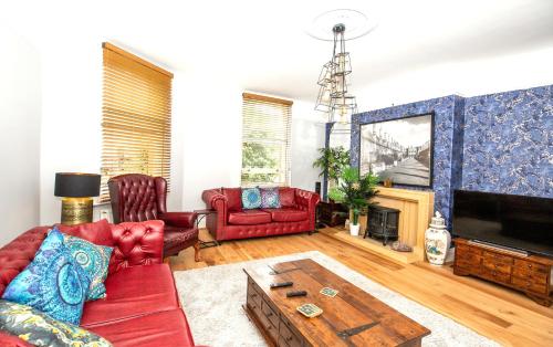 a living room with red furniture and a tv at Marketplace Glastonbury in Glastonbury