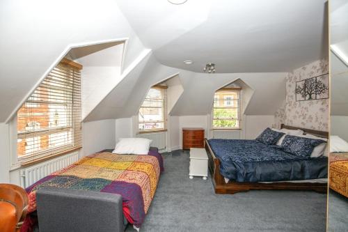 a bedroom with two beds and two windows at Marketplace Glastonbury in Glastonbury