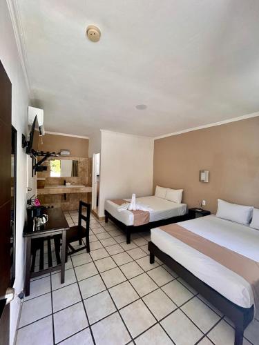 a hotel room with two beds and a desk at Maya Bric in Playa del Carmen