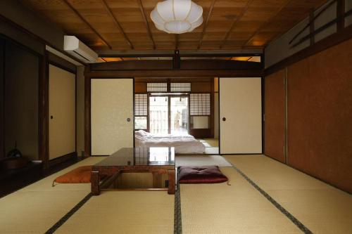 a room with a glass table and a bed at Basara Kinmokusei 金木犀Kyoto Machiya in Kyoto