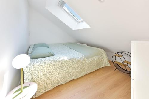 a white bedroom with a bed and a lamp at Piriac Dumet Appartement Duplex avec exterieur 4 à 6p 500m de la plage in Piriac-sur-Mer