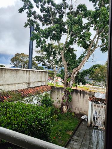 a tree next to a wall and a fence at Hotel Estação in Diamantina