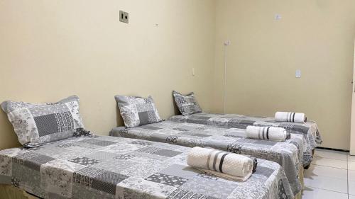 two beds sitting next to each other in a room at Pousada Conviver - Unidade 2 in Juazeiro do Norte
