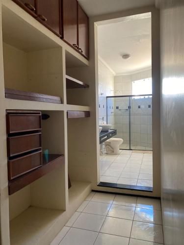 a bathroom with a toilet and a glass door at Pousada Conviver - Unidade 2 in Juazeiro do Norte