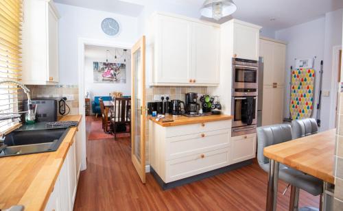 a kitchen with white cabinets and a wooden floor at Marketplace Glastonbury in Glastonbury