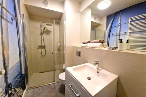 une salle de bain avec un lavabo, une douche et des toilettes dans l'établissement Lux Apartment Art, à Polanica-Zdrój