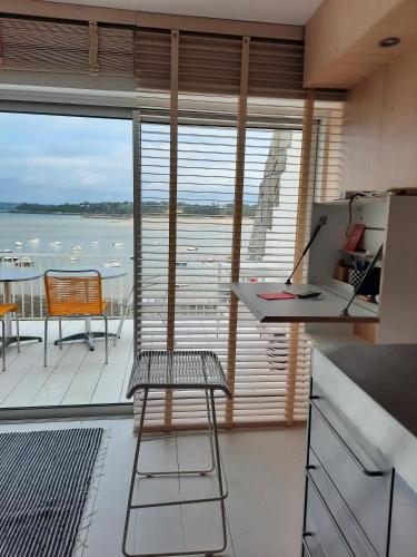 a kitchen with a balcony with a view of the water at Appartement pieds dans l'eau, Locquirec in Locquirec