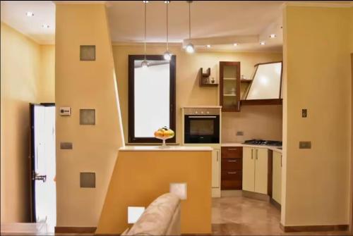 une cuisine aux murs jaunes et une grande fenêtre dans l'établissement Casa Beatrice, à Campochiaro