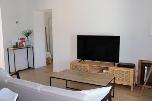 a living room with a couch and a flat screen tv at Casa da Moura in Santiago do Cacém