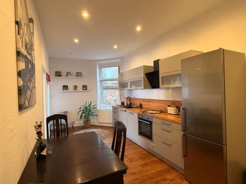 a kitchen with a stainless steel refrigerator and a table at Entspannt Mittendrin in Hannover