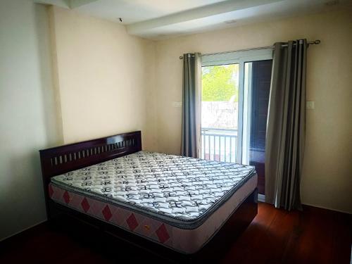 a bed in a room with a window and a bed sidx sidx sidx at Johana Inn in Cochin