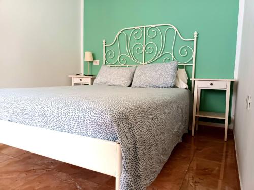 a bedroom with a bed with a green headboard at la casa de las palmeras in Arrecife