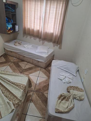 a room with two beds and a window at Pousadaa São João 144 in Aparecida