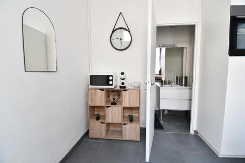 Un pasillo con un baño con lavabo y espejo. en Le Nid Douillet Saint-Dizier Republic, en Saint-Dizier