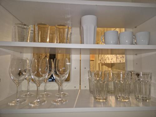 a bunch of wine glasses sitting on a shelf at Top-Floor Hideout with Sauna near City Center in Rovaniemi