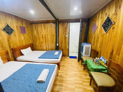 a bedroom with two beds and a table and chairs at Homestay Chinh Bi in Yên Bái