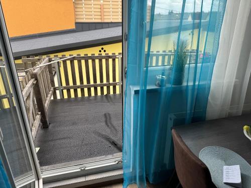 a balcony with a blue curtain and a window at Wohnung 3 Ossi in Oedt