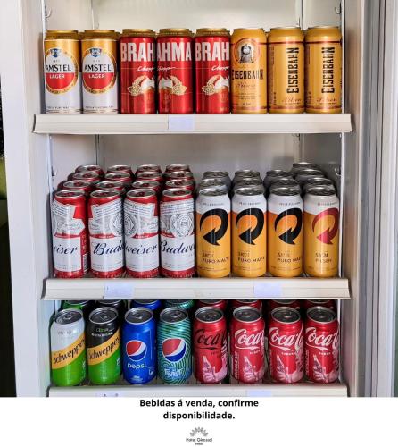 a refrigerator filled with lots of cans of soda at Hotel Girassol in Imbé