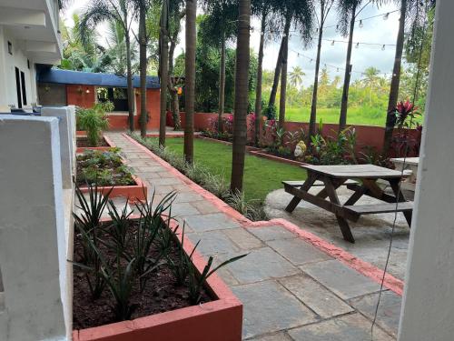 モージムにあるHotel 14 Pods Morjimの庭園内のピクニックテーブルとベンチ