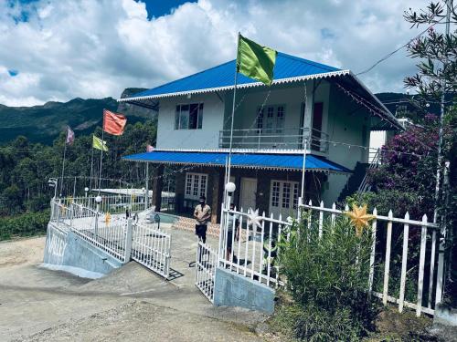 a man standing in front of a house with flags at Aden Valley Resort in Kanthalloor