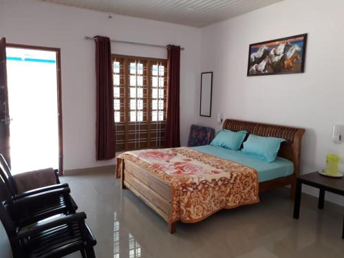 a bedroom with a bed and a chair at Aden Valley Resort in Kanthalloor