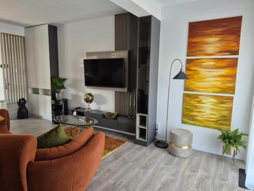 Una sala de estar con un sofá y un televisor. en Casa Sunset, en Sînpetru