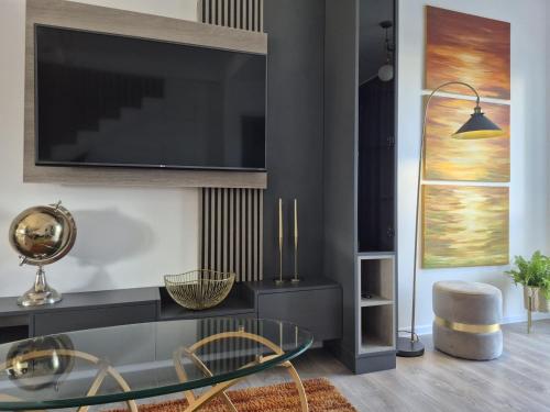 sala de estar con TV y mesa de cristal en Casa Sunset, en Sînpetru