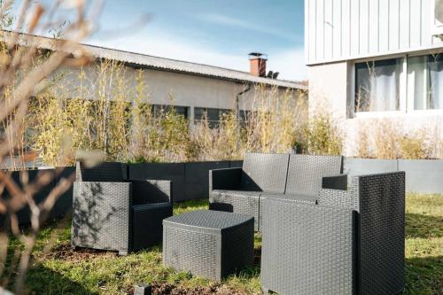 a group of black and white chairs in a yard at Hôtel L'ange de la vallée in Oyonnax
