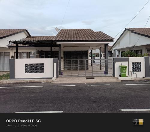 a building with a gate in a parking lot at Homestay faleeq in Jerantut